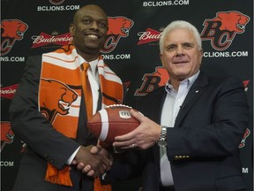 Former Edmonton Eskimos general manager Ed Hervey, left, is introduced Thursday as the new GM of the B.C. Lions. Wally Buono will remain as head coach of the CFL team for one more year.