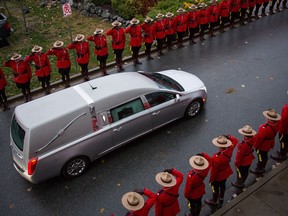 RCMP officers salute the hearse carrying the body of Abbotsford Police Const. John Davidson, who was killed in the line of duty on Nov. 6, after a memorial in Abbotsford, B.C., on Sunday November 19, 2017.