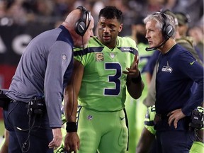 Seattle Seahawks quarterback Russell Wilson (3) speaks with head coach Pete Carroll, right, and assistant head coach Tom Cable during an NFL football game against the Arizona Cardinals in Glendale, Ariz. The Seahawks face questions about how the team handled the concussion protocol with Wilson.