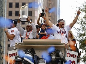 Houston Mayor Sylvester Turner (left) holds up the Commissioner’s Trophy for the World Series champions as Houston Astros World Series MVP George Springer (No. 4, right) leads the cheers during Friday’s parade honouring champion Astros through the streets of Houston.