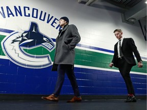 Brock Boeser (left) and Troy Stecher of the Vancouver Canucks walks to their dressing room before their NHL game against the Calgary Flames at Rogers Arena on Sunday. Boeser was injured early in the second period when blocking a shot.