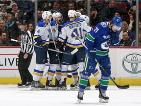 Loui Eriksson of the Vancouver Canucks looks on dejected as Kyle Brodziak of the St. Louis Blues is congratulated by teammates after scoring during their NHL game at Rogers Arena on Saturday.
