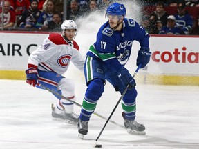 Phillip Danault of the Canadiens tries to corral Canucks centre Nic Dowd on Dec. 19.