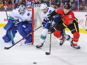 CALGARY, AB - DECEMBER 9: Matt Stajan #18 of the Calgary Flames chases the puck against Sven Baertschi #47 of the Vancouver Canucks during an NHL game at Scotiabank Saddledome on December 9, 2017 in Calgary, Alberta, Canada.