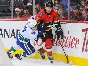 Sam Bennett of the Calgary Flames battles for the puck against Nic Dowd of the Vancouver Canucks during Saturday's game in Calgary. His quick insertion into the lineup didn't go as planned for the former King, as it was a rough first game.