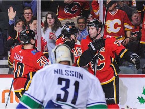 Troy Brouwer, right, of the Calgary Flames celebrates with his teammates after scoring against the Vancouver Canucks during Saturday's game at Scotiabank Saddledome in Calgary.