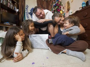 Allan and Jolene Williams, holding son Taylor, distract the youngster Thursday with the help of daughters Summer and Autumn at their Vancouver home.