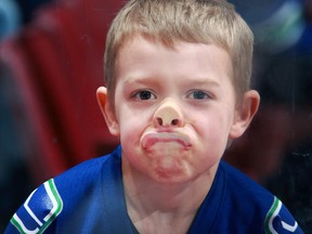 A young Vancouver Canucks fan pushes his face up against the glass as he watches the Nashville Predators demolish his team 7-1 at Rogers Arena on Wednesday night.