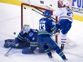 Vancouver Canucks centre Henrik Sedin (33) looks on as Montreal Canadiens left wing Alex Galchenyuk (27) sends a shot past Vancouver Canucks goalie Anders Nilsson in the third period.