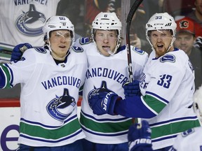 Brock Boeser, centre, received quite the compliment from Henrik Sedin, right, this week.
