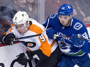 Brendan Gaunce of the Canucks checks Philadelphia Flyers' defenceman Ivan Provorov during Thursday's NHL action at Rogers Arena in Vancouver.