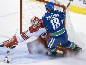 Vancouver Canucks right wing Jake Virtanen (18) tires to get a shot past Carolina Hurricanes goalie Scott Darling (33) during second period NHL action in Vancouver, Tuesday, Dec. 5, 2017.