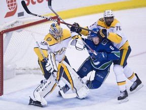 Nashville defenceman P.K. Subban, who scored two soft goals Wednesday, including one from centre ice, gives Canucks' forward Brock Boeser a hard time in front of Predators' goalie Pekka Rinne during first-period NHL action in Vancouver.
