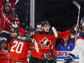 Canada's Jonah Gadjovich celebrates his first goal with teammate Michael McLeod against Slovakia.