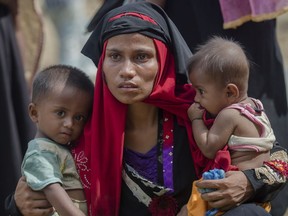 A Rohingya Muslim woman, who crossed over from Myanmar into Bangladesh, holds her children after the government moved them to newly allocated refugee camp areas. Myanmar, a predominantly Buddhist nation of 60 million, was basking in international praise just a few years ago as it transitioned to democracy after a half-century of dictatorship. Since then, a campaign of killings, rape and arson attacks by security forces and Buddhist-aligned mobs have sent more than 850,000 of the country's 1.3 million Rohingya fleeing.