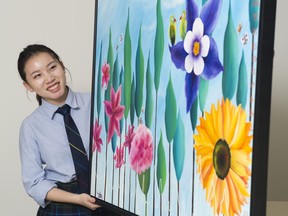 Grade 11 artist Carrie Zhou holds her The Art of Death painting.