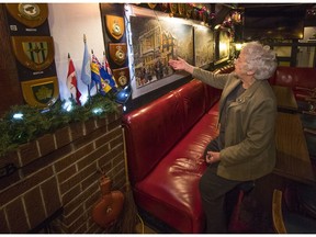 Rita Johnson points to one of the numerous Christmas paintings by former bartender Fred Thearle. Hanging in the Billy Bishop Legion, they're inspired by Charles Dickens' Christmas Carol.