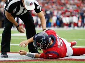 Referee John Hussey checks on Houston Texans quarterback Tom Savage following a hard hit on Dec. 10, 2017