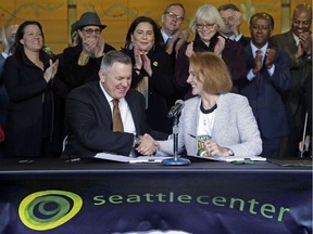 Seattle Mayor Jenny Durkan, right, shakes hands with Los Angeles-based Oak View Group CEO Tim Leiweke after they signed an agreement to renovate KeyArena, Wednesday, Dec. 6, 2017, in Seattle. Durkan said that the deal is the best path right now for Seattle to get an NHL team and bring back the SuperSonics.