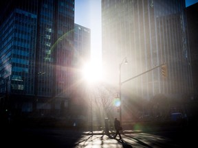 The sun shines through fog as a man crosses a street in downtown Vancouver on Wednesday, Dec. 6, 2017. More sun is expected for the foreseeable future in the Lower Mainland.