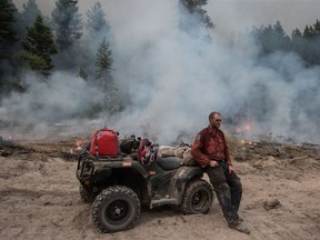 B.C. Wildfire Service firefighter Jordain Lamothe takes a brief break while conducting a controlled burn to help prevent the Finlay Creek wildfire from spreading near Peachland, B.C., on Thursday, September 7, 2017.