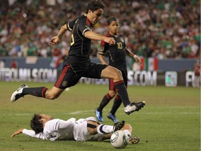 Efrain Juarez leaps over New Zealand's Michael Fitzgerald in a 2011 game in Denver, Colorado.
