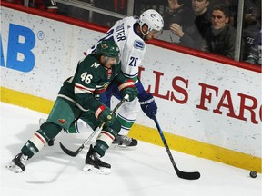 Jared Spurgeon  chases the puck against Brandon Sutter.