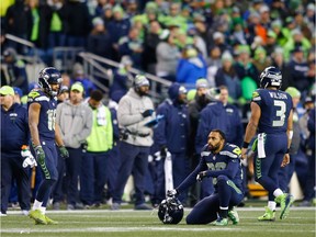 Wide receiver Doug Baldwin #89 of the Seattle Seahawks kneels as he reacts along with Tyler Lockett #16 late in the fourth quarter at CenturyLink Field on December 31, 2017 in Seattle, Washington. The Arizona Cardinals beat the Seattle Seahawks 26-24.
