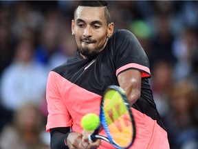 Australia's Nick Kyrgios hits a return against Brazil's Rogerio Dutra Silva during their men's singles first round match on day one of the Australian Open tennis tournament in Melbourne on January 15, 2018.