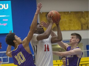 North Kitsap's Kai Warren, left, and Derek Zinn, right, defend against Brentwood College's Somto Dimonachie during the Vikes Alumni Senior Boys Invitational Tournament at  CARSA gym in Victoria on Dec. 28, 2017.