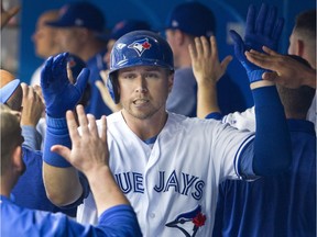 Toronto Blue Jays' Justin Smoak gets high fives in the dugout after hitting a three-run home run during first inning AL baseball action against the Boston Red Sox, in Toronto in June.