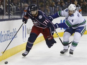 Nick Foligno of the Columbus Blue Jackets is pestered by Canucks' defenceman Michael Del Zotto during NHL action Friday in Columbus, Ohio. Vancouver snapped a five-game losing streak with a 5-2 victory at Nationwide Arena.