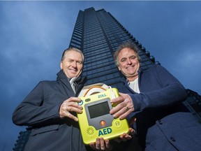 Dr. Garry Henderson, left, who convinced his Yaletown condo strata to install a few AEDs in the building, with his friend and neighbour Tony Fagan, who suffered a heart attack in the building, at Vancouver on Jan. 9. A reader says all schools should also have the life-saving devices.