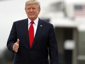 U.S. President Donald Trump gives a thumbs up as he boards Air Force One on Oct. 11, 2017, at Andrews Air Force Base, Md.