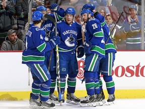 Bo Horvat (centre) is congratulated by teammates after scoring during the Canucks' game against the Colorado Avalanche at Rogers Arena on Jan. 30, 2018, in Vancouver.