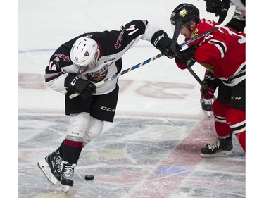 Vancouver Giants #14 James Malm looks for the puck after facing off against Portland Winterhawks #38 Reece Newark in the first period of a regular season WHL hockey game at LEC, Vancouver, January 20 2018.