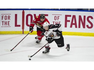 Vancouver Giants #7 Ty Ronning moves the puck past Portland Winterhawks #44 Keoni Texeira in the second period of a regular season WHL hockey game at LEC, Vancouver, January 20 2018.
