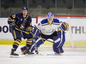 Matt Hewitt, UBC men's hockey goalie, battles with University of Lethbridge forward Justin Valentino.