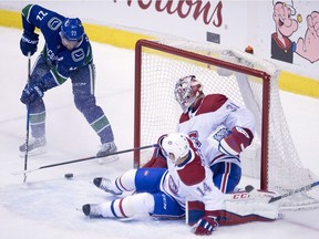 Vancouver Canucks left wing Daniel Sedin (22) sends a shot past Montreal Canadiens' Tomas Plekanec (14) and goalie Carey Price (31) during second period NHL action in Vancouver in December.