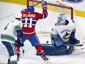Vancouver Canucks goaltender Anders Nilsson is scored on by  Alex Galchenyuk (not shown) as Canucks' Michael Del Zotto and Canadiens' Brendan Gallagher vie for position.