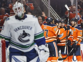 Edmonton Oilers celebrate a goal by Jesse Puljujarvi (98) against Vancouver Canucks goalie Jacob Markstrom (25) during second period NHL action in Edmonton, Alta., on Saturday.