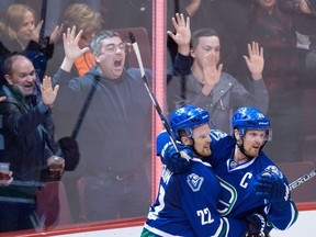 Daniel Sedin (left) and Henrik Sedin of the Vancouver Canucks celebrate following Daniel's goal against the New York Rangers during a Dec. 9, 2015 NHL game at Rogers Arena.