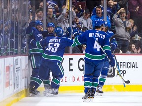 Vancouver Canucks left wing Thomas Vanek (26), of Austria, left to right, defenceman Alex Biega (55), centre Bo Horvat (53), defenceman Michael Del Zotto (4) and left wing Loui Eriksson (obscured), of Sweden, celebrate Vanek's goal against the Los Angeles Kings during the first period of an NHL hockey game in Vancouver, B.C., on Tuesday January 23, 2018.