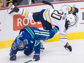 Chris Tanev and Scott Wilson go bump in the night Thursday at Rogers Arena.