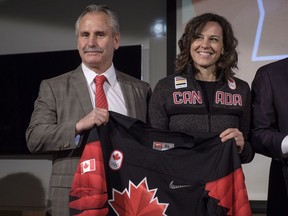 Hockey Canada's head coach Willie Desjardins and Team Canada chef de mission Isabelle Charest hold a jersey after announcing Canada's national men's team in Calgary on Jan. 11, 2018.