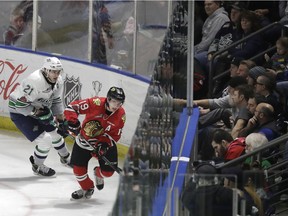 In this Jan. 9, 2018, photo, fans watch at the ShoWare Center in Kent, Wash., about 20 miles south of Seattle, as Seattle Thunderbirds' Matthew Wedman, left, challenges Portland Winterhawks' Ryan Hughes, right, during a Western Hockey League game. Hockey's history in Seattle dates back more than a century to when the Seattle Metropolitans hoisted the 1917 Stanley Cup, and all indications are that an NHL franchise could arrive sometime after 2020, depending on construction of a remodeled Seattle Center arena.