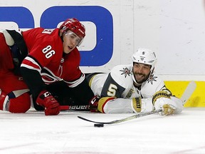 Vegas Golden Knights defenceman Deryk Engelland (right) tries to pass the puck against the Carolina Hurricanes on Jan. 21.