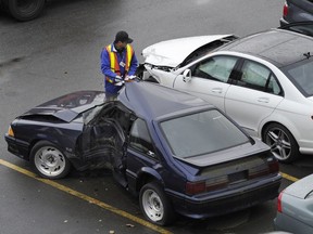 Workers at the ICBC damaged vehicle  lot at the south end of the Queensborough Bridge in Richmond.