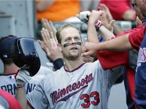 Minnesota Twins star Justin Morneau celebrates with teammates after hitting a three-run home run in the third inning of an August 2013 American League game against the Chicago White Sox in Chicago. The New Westminster native was the 2006 American League MVP award winner whose career was derailed by concussion symptoms.