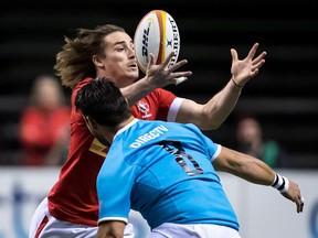 Canada's Jeff Hassler, back, bobbles the ball while being watched by Uruguay's Alejandro Nieto during the first half of a Rugby World Cup qualifier match in Vancouver, B.C., on Saturday January 27, 2018.